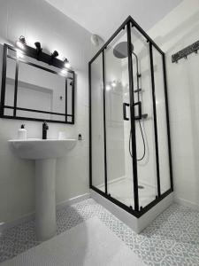 uma casa de banho com uma cabina de duche em vidro e um lavatório. em Le vieux Moyrenc em Moirans