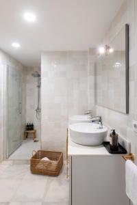 ein weißes Bad mit einem Waschbecken und einer Dusche in der Unterkunft MonKeys Apartments Luxury Puerta de la Maestranza in Sevilla