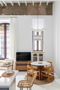ein Wohnzimmer mit einem Tisch und Stühlen in der Unterkunft MonKeys Apartments Luxury Puerta de la Maestranza in Sevilla