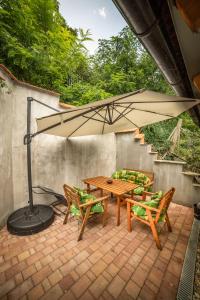 patio con tavolo, sedie e ombrellone di Vinný sklep Kovárna - Nad Presovnou a Rohatec