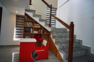een trap met een rode bar en een boekenplank bij Vaishnavam Double Bedroom Villa in Thekkady