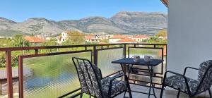 d'un balcon avec une table, des chaises et des montagnes. dans l'établissement Guesthouse Buco, à Trebinje