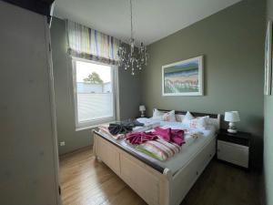 a bedroom with a bed with pink sheets and a window at Apartment Wilhelmine in Borkum