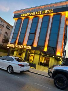 dois carros estacionados em frente a um hotel palácio de avião em Amber Palace Hotel em Istambul