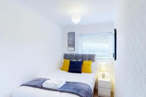 um quarto com uma cama com almofadas amarelas e azuis em Stunning Ranworth House Sleeps 5 em Bedford
