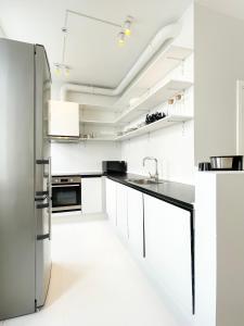 een keuken met witte kasten en een roestvrijstalen koelkast bij Beautiful One-Bedroom Flat in CPH City in Kopenhagen