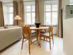 een woonkamer met een tafel en stoelen en een bank bij Beautiful One-Bedroom Flat in CPH City in Kopenhagen