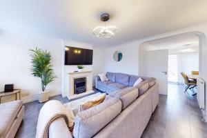 uma sala de estar com um sofá e uma lareira em Stunning Ranworth House Sleeps 5 em Bedford