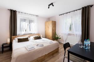 a bedroom with a bed and a desk and windows at Przystanek O2 in Smolniki