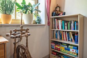 una libreria piena di libri accanto a una sedia di Glocklechnhof Sonnenschein a Cadipietra