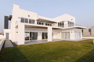 a white house with a green lawn at Beachfront Villa in Swakopmund