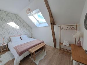 una camera con un grande letto e un lucernario di Gîte du Plantagenêt - Piscine intérieure privative a Rouez Altre 29 foto
