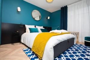 um quarto azul com uma cama grande e um cobertor amarelo em Art déco appartement Disneyland em Chessy