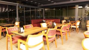 un restaurante con mesas y sillas de madera y ventanas en Amber Palace Hotel, en Estambul