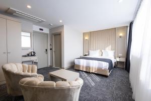 ein Hotelzimmer mit einem Bett und zwei Stühlen in der Unterkunft Moss Hotel YENİKAPI in Istanbul