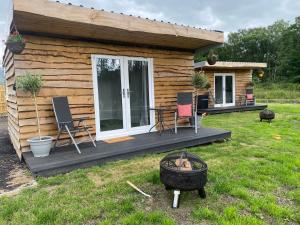 a log cabin with a table and chairs in the yard at Devon River Glamping Pods in Alloa