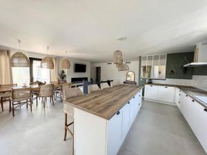 a large kitchen with a large wooden counter top at Well’Home Bali - Superbe villa au Nord de Toulouse in Mirepoix-sur-Tarn