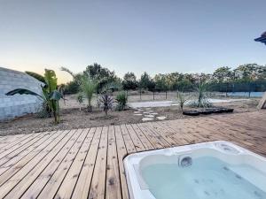 einen Whirlpool auf einer Holzterrasse in der Unterkunft Well’Home Bali - Superbe villa au Nord de Toulouse in Mirepoix-sur-Tarn