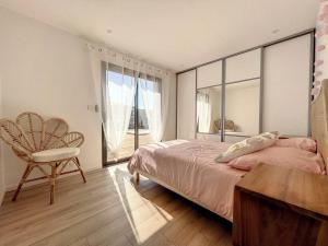a bedroom with a bed and a chair and a window at Well’Home Bali - Superbe villa au Nord de Toulouse in Mirepoix-sur-Tarn +12 photos