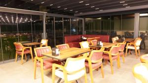 een restaurant met houten tafels, stoelen en ramen bij Amber Palace Hotel in Istanbul