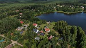 an aerial view of a house on the shore of a lake at Przystanek O2 in Smolniki