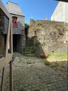 an old stone building with a window and a wall at L’atelier, appartement lumineux et cosy in Ploërmel