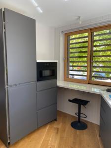 a kitchen with a refrigerator and a stool in it at L’atelier, appartement lumineux et cosy in Ploërmel