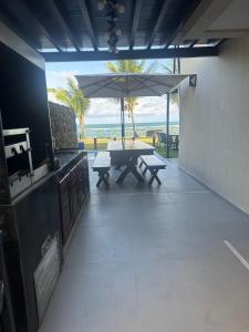 un patio con mesa de picnic y sombrilla en Ekoara Residence bangalô 07, en Porto de Galinhas