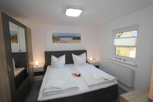 a bedroom with a bed with white sheets and a window at Ferienwohnung Franke in Zinnowitz