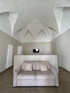 a white couch in a room with a ceiling at Il Soprano in Altamura