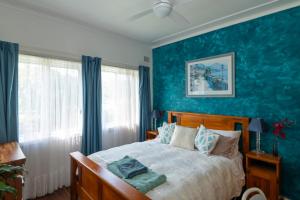a bedroom with a bed with a blue wall at Kurranulla Sapphire - U3 in Cronulla
