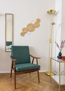 una sala de estar con una silla verde y una lámpara. en 96m2 of comfort and style: 4BD apartment in Old town, en Bratislava