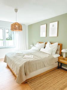 um quarto com uma cama grande e almofadas brancas em MELLoWY 10 Min bis zur Messe KA em Rheinstetten