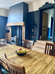 uma sala de jantar com uma mesa de madeira com uma taça de fruta em La Ferme em Ascq