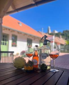 una mesa con dos copas y una botella de vino en Pannonhalma Várlak Vendégház, en Pannonhalma