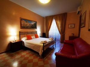 a bedroom with a bed and a red couch at Maestoso Appartamento Turistico in Rome