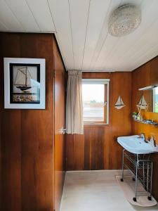 een badkamer met een wastafel en een raam bij Woonboot in Sumar gelegen tussen Leeuwarden en Drachten in Suameer