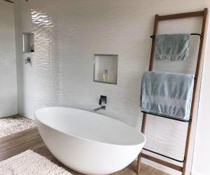 a white bath tub in a bathroom with a towel rack at Walkersons Estate- Outcrop in Dullstroom
