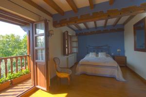 ein Schlafzimmer mit einem Bett und einem Balkon in der Unterkunft La Casa del Bosco in Suances