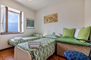Cette chambre comprend deux lits et un canapé vert. dans l'établissement Casa Non Ti Scordar di Me, 