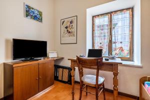 Cette chambre comprend un bureau avec une télévision et une chaise. dans l'établissement Casa Non Ti Scordar di Me, 