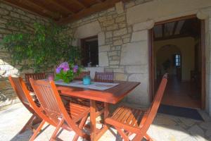 einen Holztisch und Stühle auf einer Terrasse in der Unterkunft La Casa del Bosco in Suances