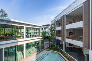 una imagen de un edificio de apartamentos con piscina en Bella Nara Phuket Naiyang Beach en Nai Yang Beach