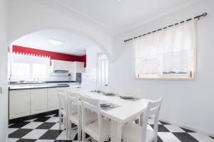 a white kitchen with a black and white checkered floor at Villa Heredia by GALMI in Ribeira Brava