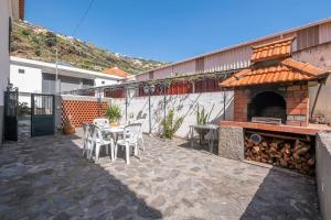 a patio with a table and a pizza oven at Villa Heredia by GALMI in Ribeira Brava