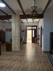 a living room with a tile floor and a chandelier at Entre montañas y mar, Casa Quim Montesa 