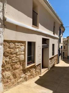 a building with a stone wall and a window at Entre montañas y mar, Casa Quim Montesa 