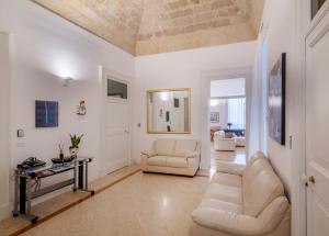 ein Wohnzimmer mit 2 Stühlen und einem Tisch in der Unterkunft VIANNA SUITES SPA in Lecce