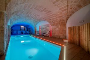 a swimming pool in a building with a brick wall at VIANNA SUITES SPA in Lecce