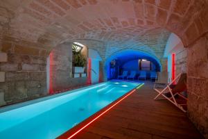 einen Innenpool in einem Gebäude mit Ziegelwand in der Unterkunft VIANNA SUITES SPA in Lecce